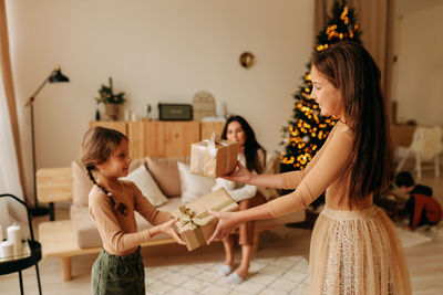 Side view of mother and daughter at home