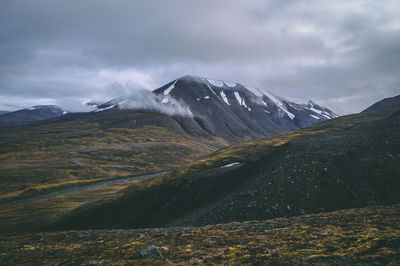 Scenic view of mountains against cloudy sky