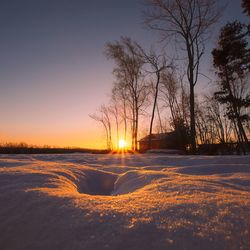 Scenic view of snow against clear sky during sunset