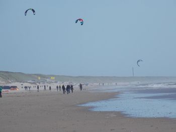 People on beach against clear sky