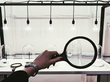 Close-up of hand holding magnifying glass at laboratory