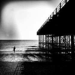 Silhouette man standing on beach against sky