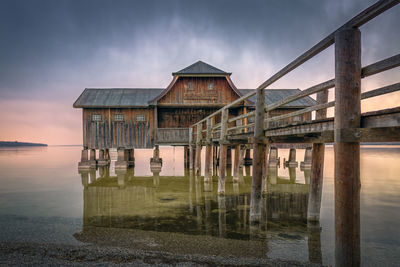 Pier over sea against sky during sunset