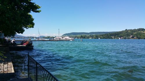 Scenic view of bay against clear blue sky