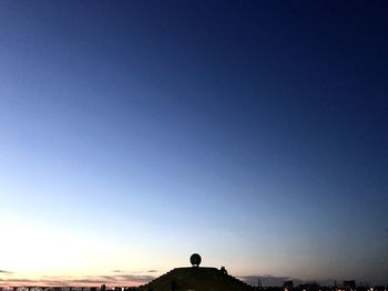 Silhouette built structure against clear blue sky