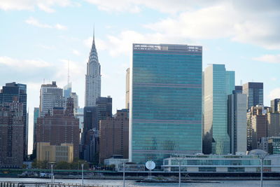 Skyscrapers in city against cloudy sky