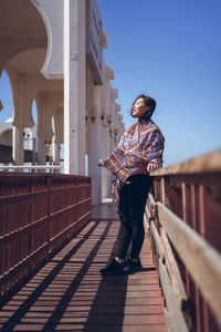 Full length of man standing on bridge against sky