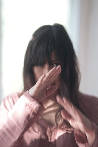 Portrait of woman covering face with hand