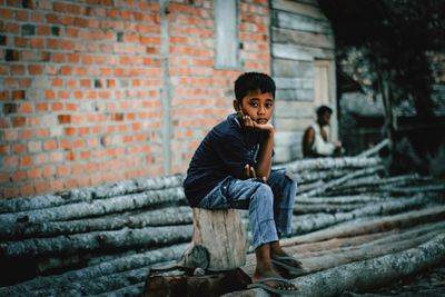 Portrait of smiling boy against brick wall