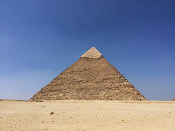 Castle on desert against clear blue sky