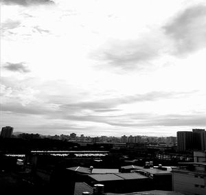 View of cityscape against cloudy sky