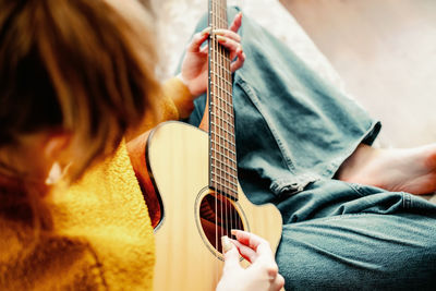 Midsection of woman playing guitar