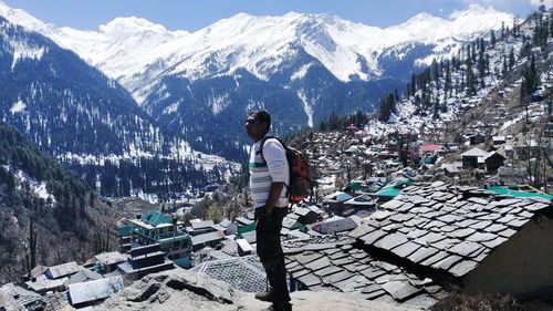 Rear view of man on snowcapped mountains during winter