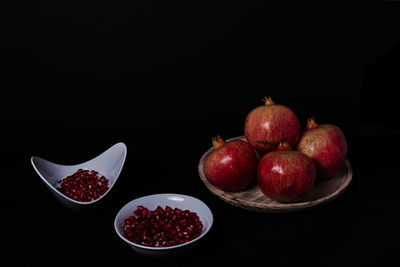 Close-up of fruits in bowl against black background