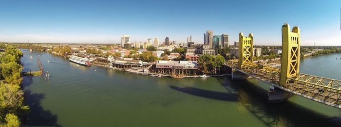 Panoramic shot of bridge by river against city