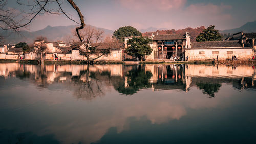Reflection of buildings on lake against sky