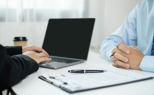 Midsection of businessman working on table