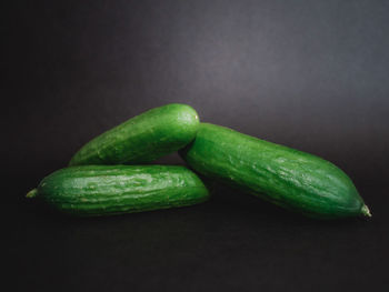 Close-up of green chili pepper on table against black background