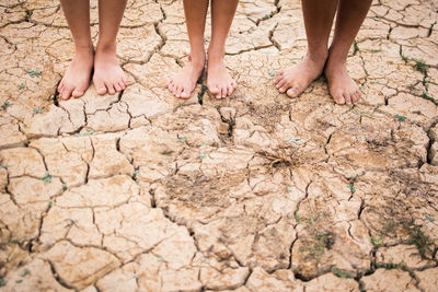 Low section of people standing on cracked field