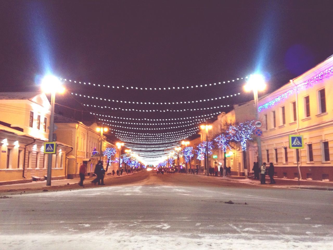 illuminated, night, architecture, building exterior, built structure, the way forward, street light, lighting equipment, street, city, transportation, diminishing perspective, road, vanishing point, city street, city life, sky, light - natural phenomenon, outdoors, in a row