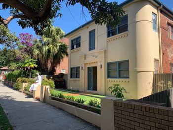 Residential building by street against sky