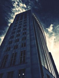 Low angle view of modern building against cloudy sky
