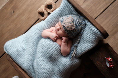 High angle view of baby hand holding wood