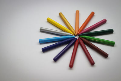 High angle view of multi colored pencils on white background