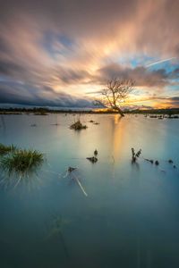 Scenic view of lake against cloudy sky