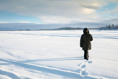 Rear view of man on snow against sky