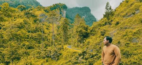 Man standing by plants against mountain