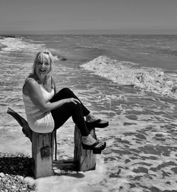 Portrait of young woman on beach against sea