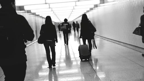 People walking with luggage on tiled flooring