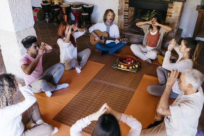 Multiracial friends meditating in music therapy at farmhouse