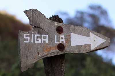 Close-up of road sign against sky