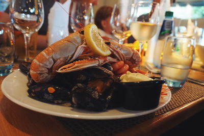 Close-up of seafood served in plate with drinks on table at restaurant