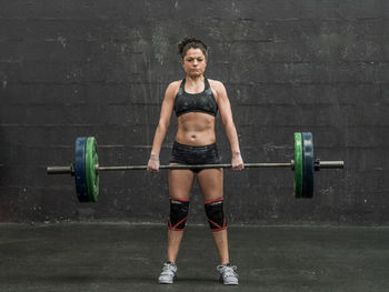 Full length of woman doing deadlift