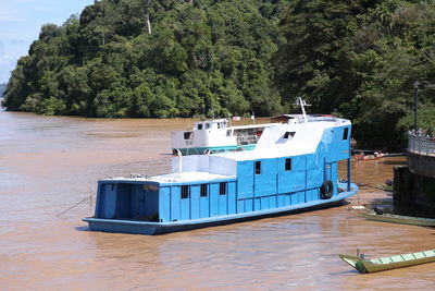 Ship moored on sea against trees