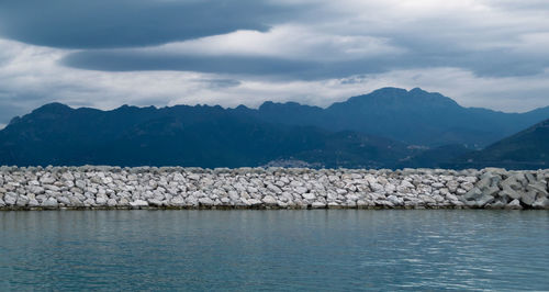 Scenic view of lake by mountains against sky