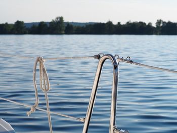 Close-up of sailboat railing against lake