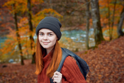 Portrait of smiling young woman in park during autumn