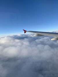 Airplane flying over cloudscape against blue sky