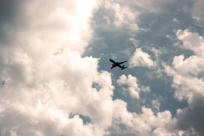 Low angle view of silhouette airplane flying in sky