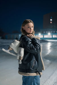 Portrait of young woman standing against sky at night