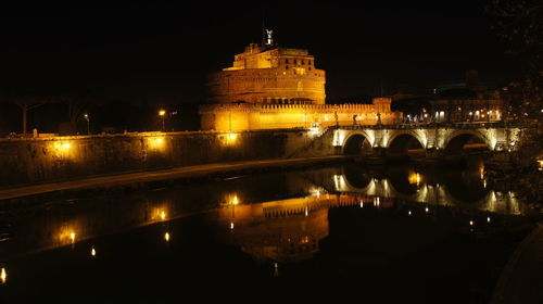 Illuminated bridge over river at night