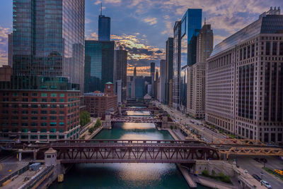 Bridge over river in city against sky