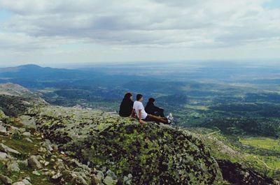 Rear view of people sitting on landscape