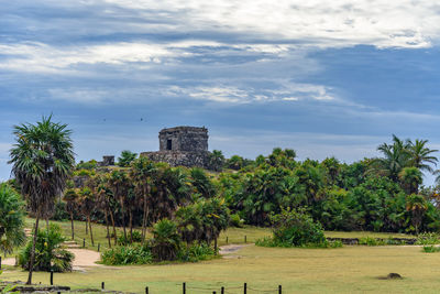 Trees in front of castle against sky
