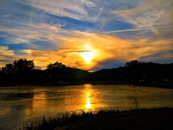 Scenic view of river against sky at sunset