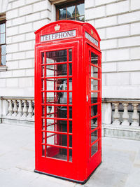 Red telephone booth on footpath